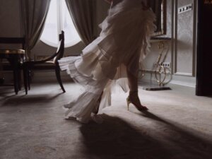 Detailbild einer Frau im cremefarbenen Abendkleid aus Volants