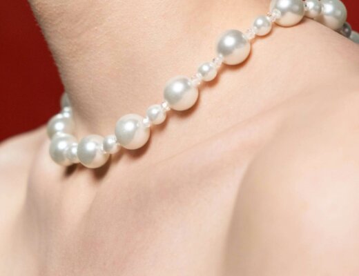 Perlenkette, die um den Hals einer Frau liegt