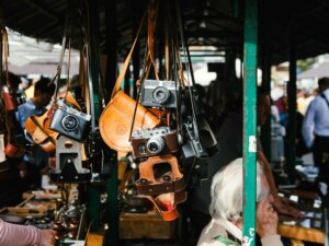 Kameras und Kamerataschen hängen an einem Flohmarktstand