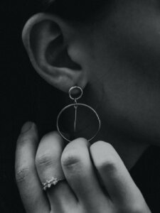 Fokus auf minimalistischem Ohrring und zwei Ringe