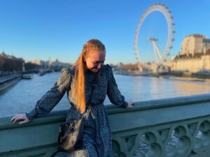 Junge Frau auf einer Brücke mit Blick auf das Riesenrad London Eye