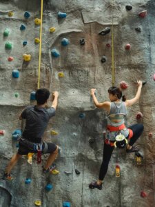 Eine Frau und ein Mann an einer Indoor-Kletterwand