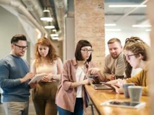 Sechs junge Kollegen stehen an einer Arbeitstheke und diskutieren