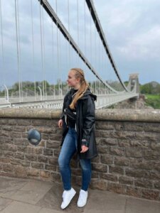 Frau mit geflochtenen Haaren vor einer Hängebrücke