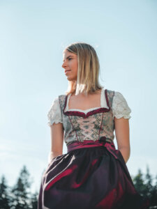 Frau in einem roten Dirndl blickt zur Seite