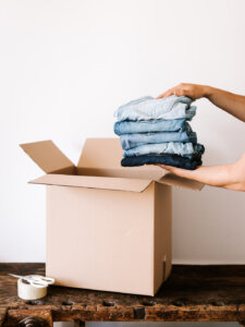 Ein Stapel Jeans wird in einen Karton gepackt