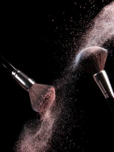 Zwei Make-up-Pinsel mit Puder benetzt