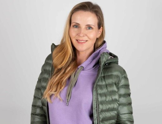 Frau mit einer grünen Übergangsjacke und lila Hoodie