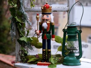 Ein alter Nussknacker steht auf einer weihnachtlich dekorierten Fensterbank