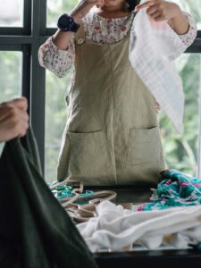 Zwei Frauen sortieren Kleidung auf einem Tisch