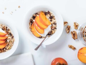 Weiße Schalen von oben, die mit Müsli und Obst gefüllt sind