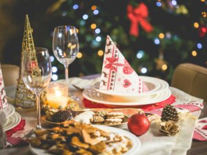 Ein Tisch, der weihnachtlich dekoriert ist und auf dem ein Teller mit Serviette und ein Glas stehen