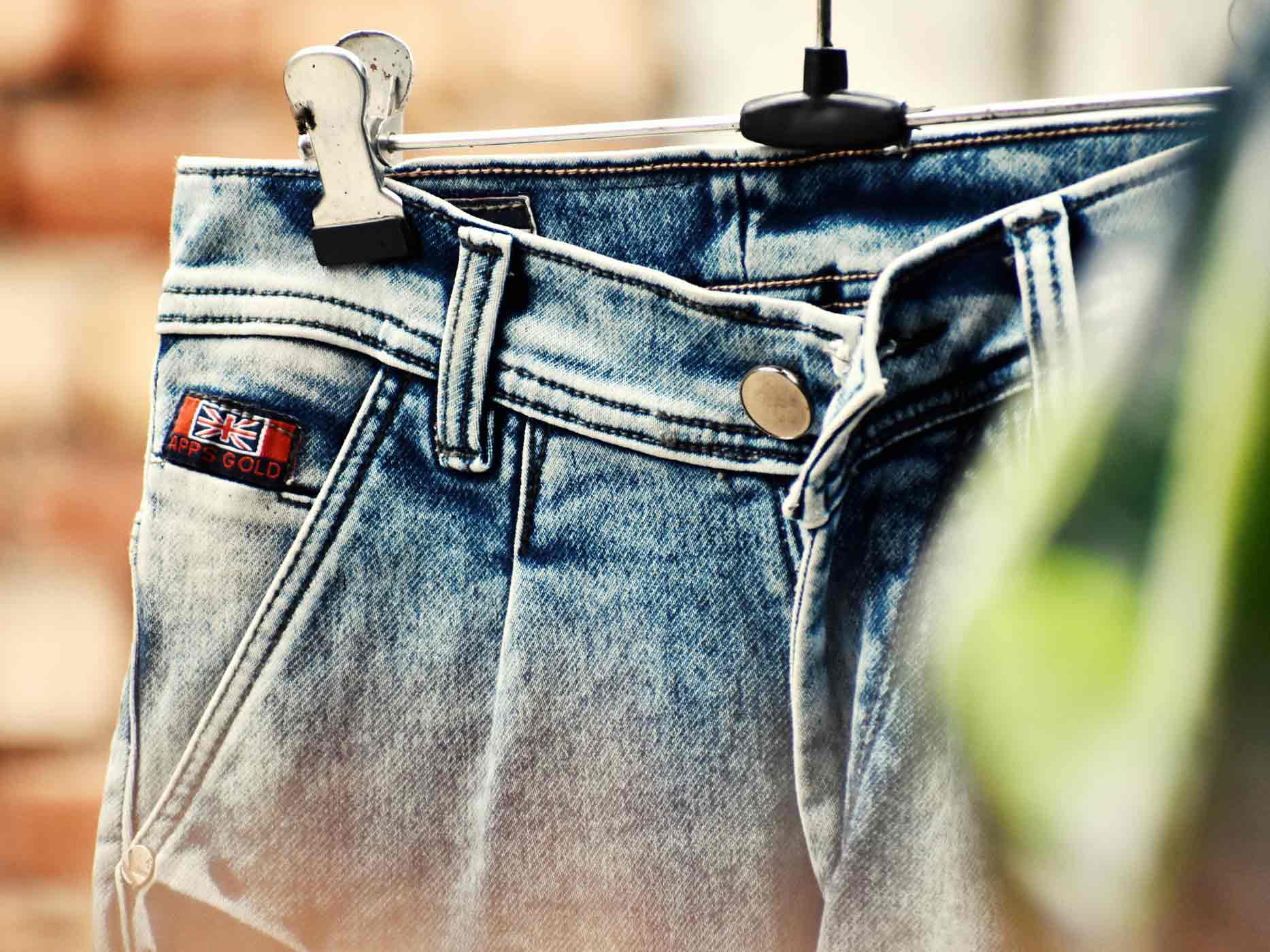 Jeans hängt an einem Kleiderbügel