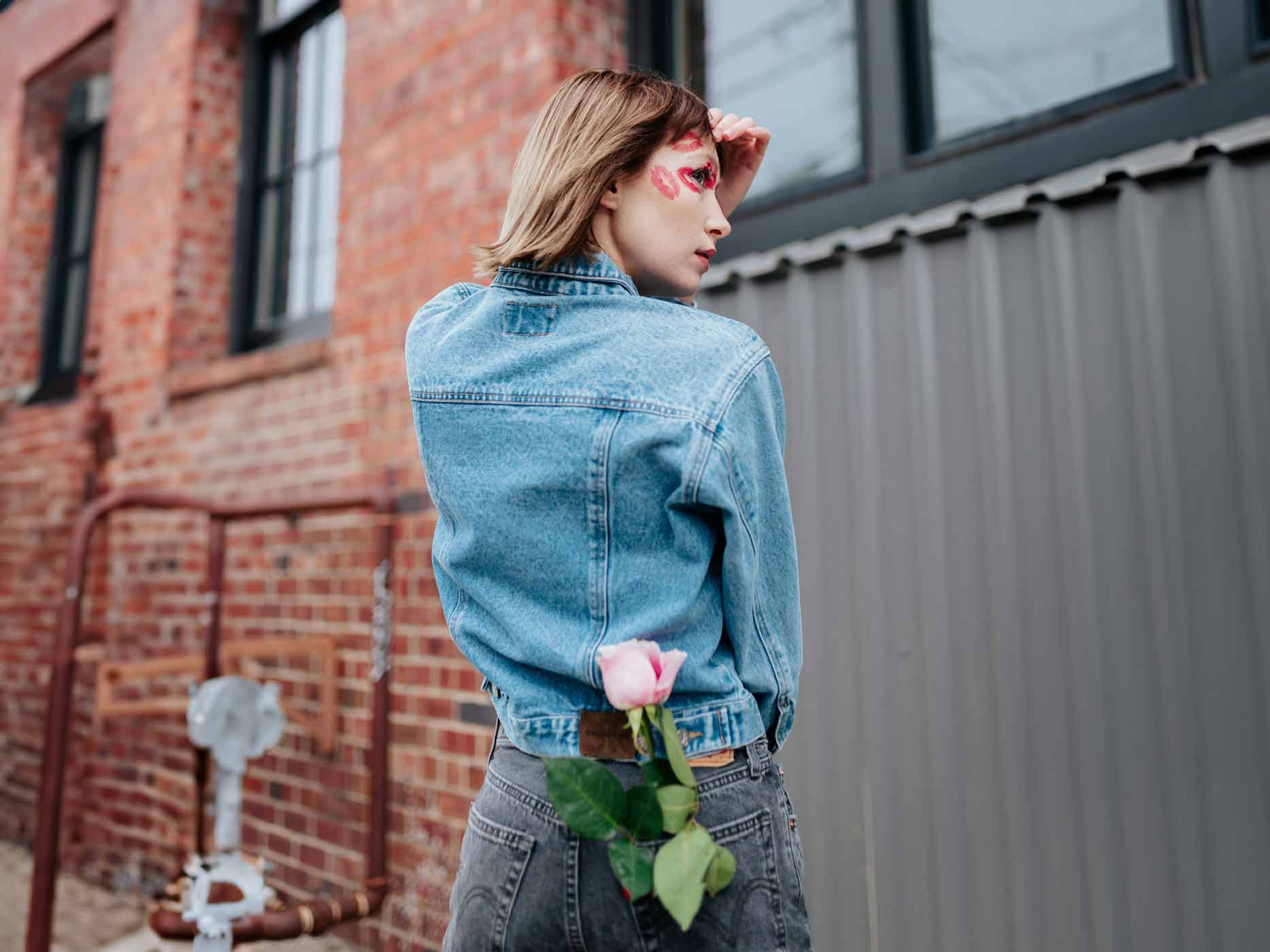 Frau trägt blaue Jeansjacke und dunkelgraue Jeanshose