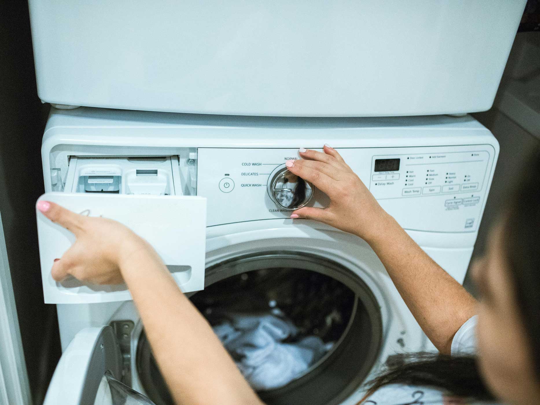Frau stellt eine Waschmaschine an