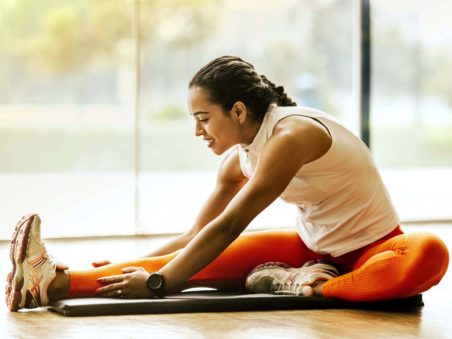 Frau dehnt sich auf einer Yogamatte