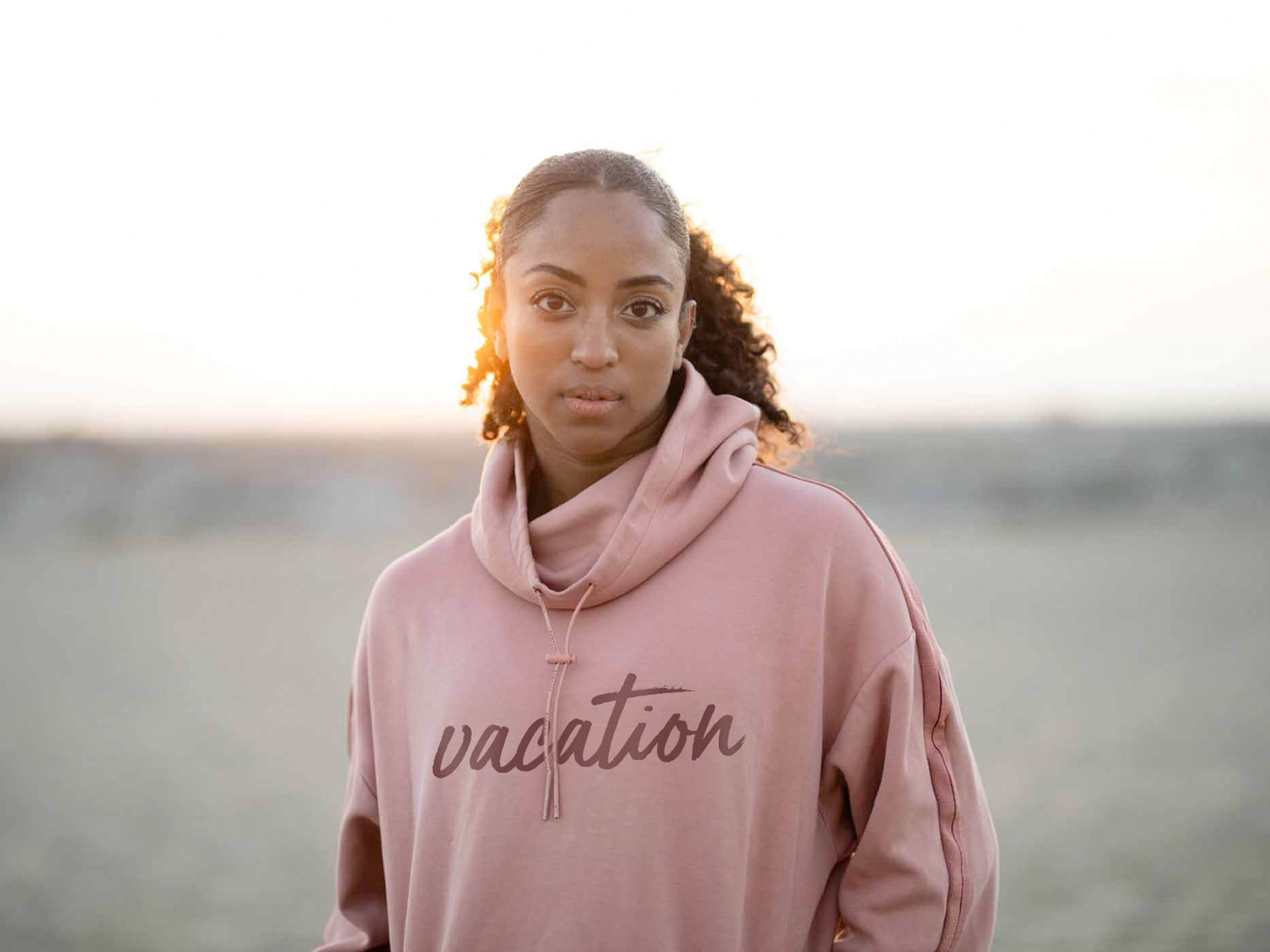 Frau im rosa Hoodie mit Vacation-Wording