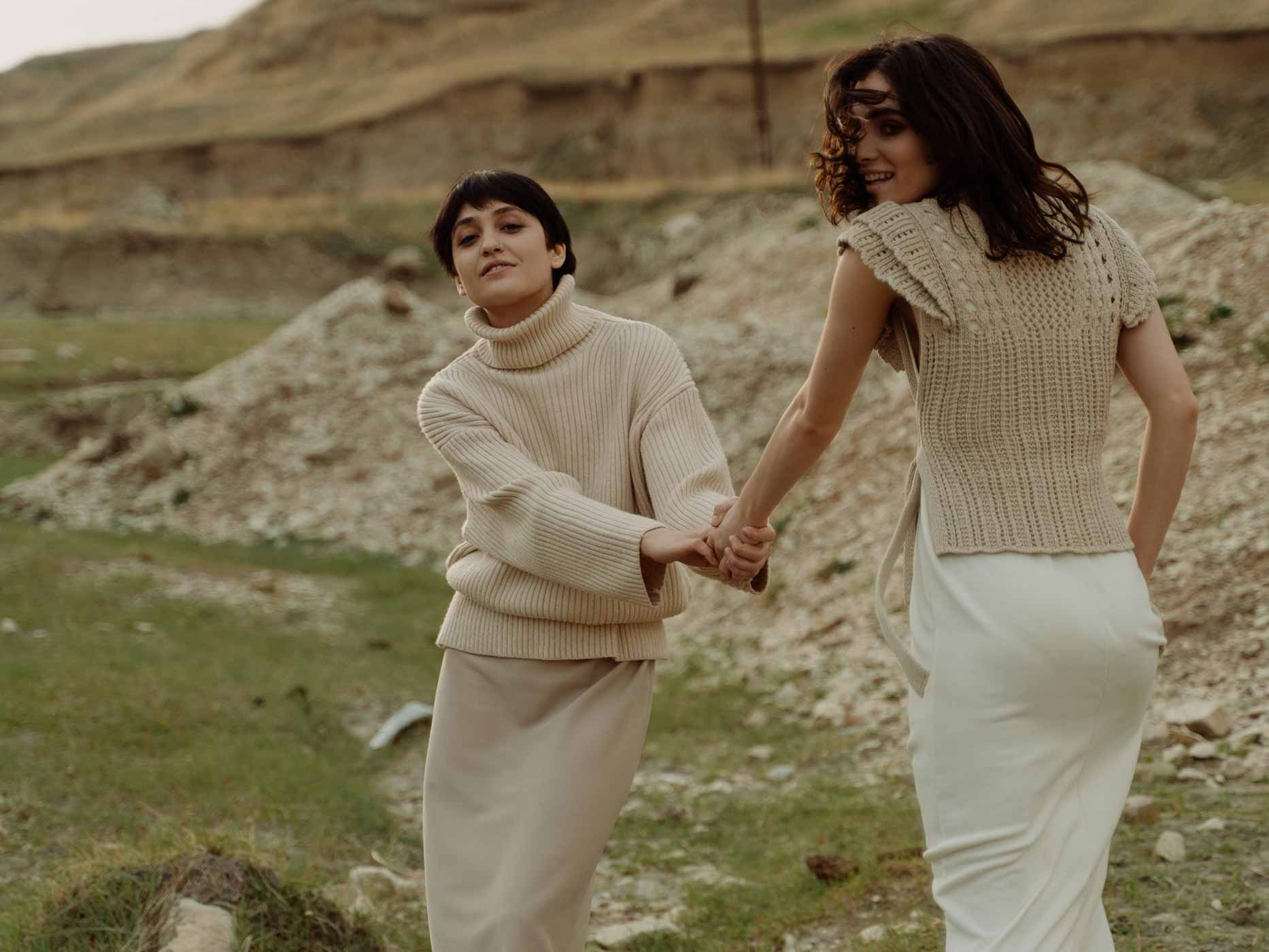 Zwei Frauen draußen in der Natur tragen Oberteile und Röcke in Erdtönen