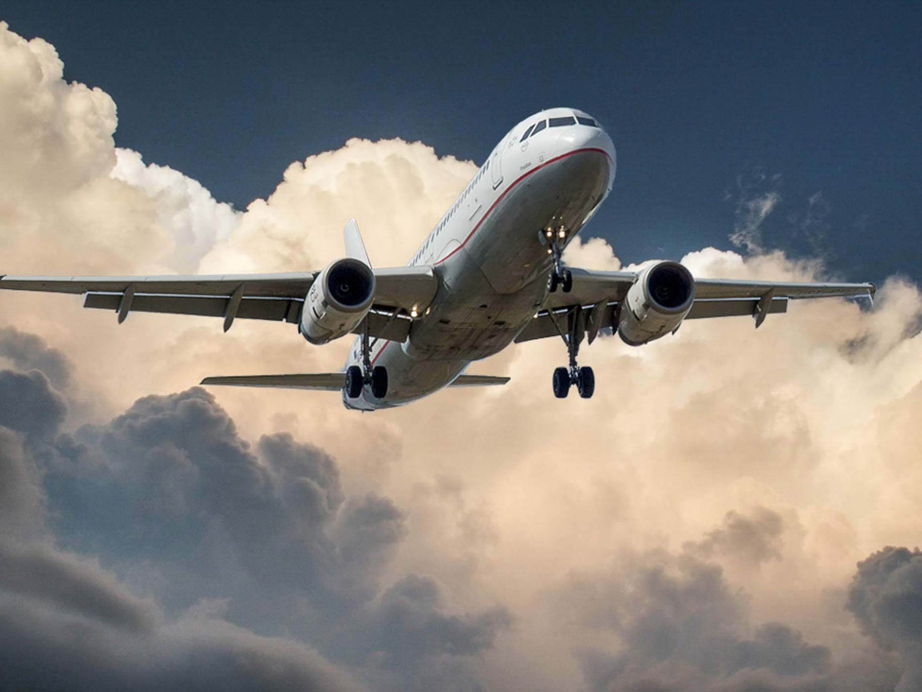 Weißes Flugzeug beim Starten mit Wolken im Hintergrund