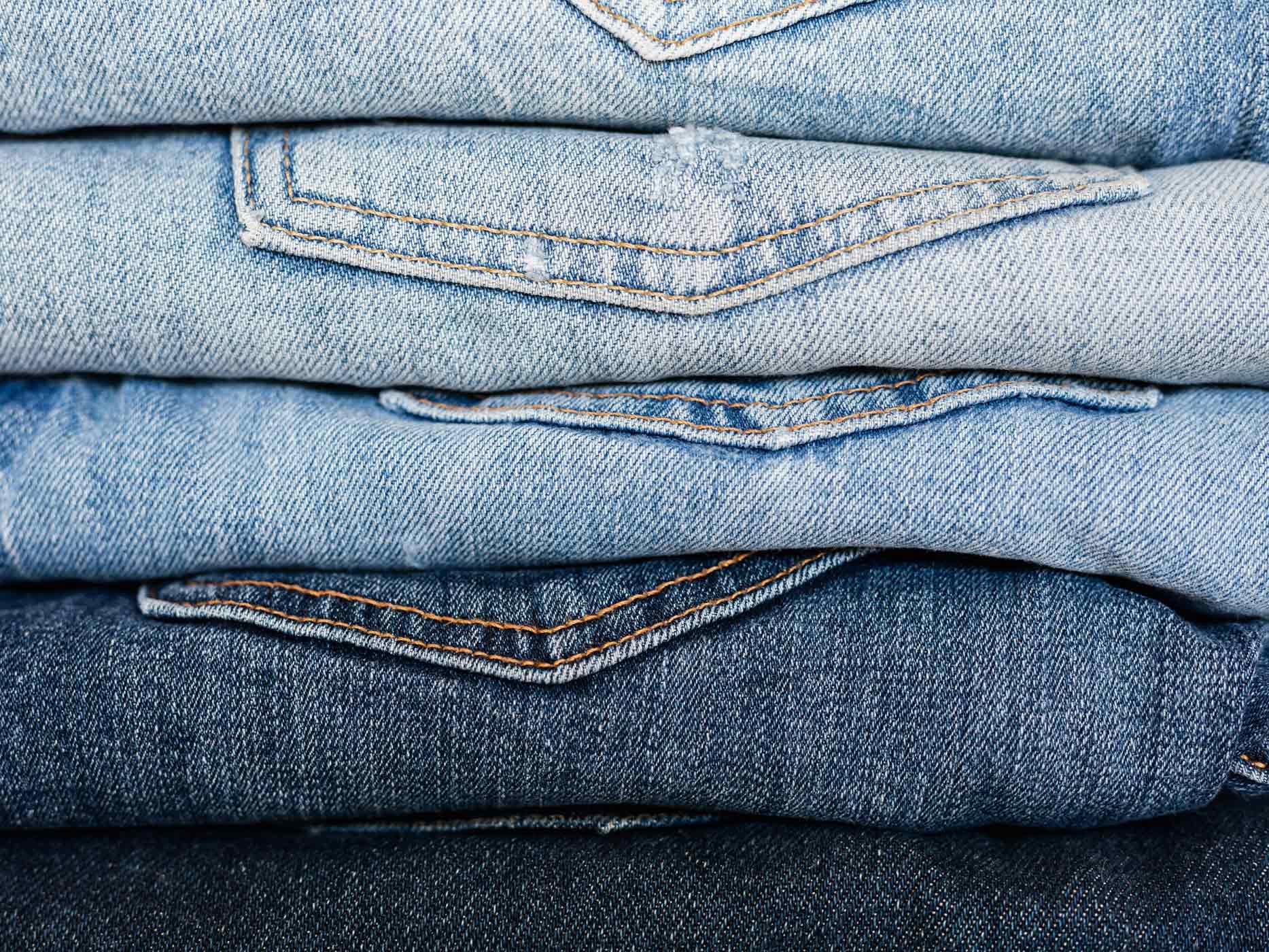 Verschiedenfarbige Jeans gestapelt auf einem Haufen
