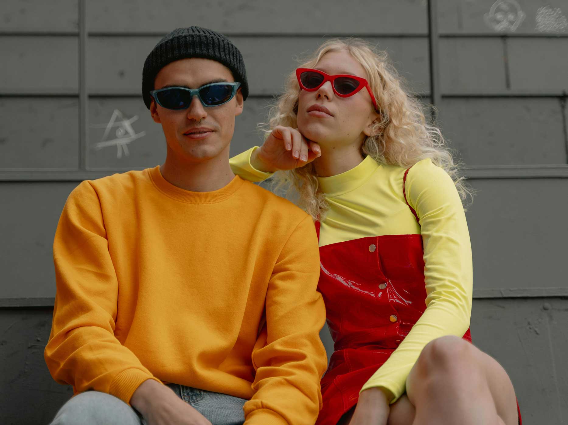 Junge und Mädchen tragen auffällige, knallige Kleidung in den Neonfarben, Rot, Gelb und Orange