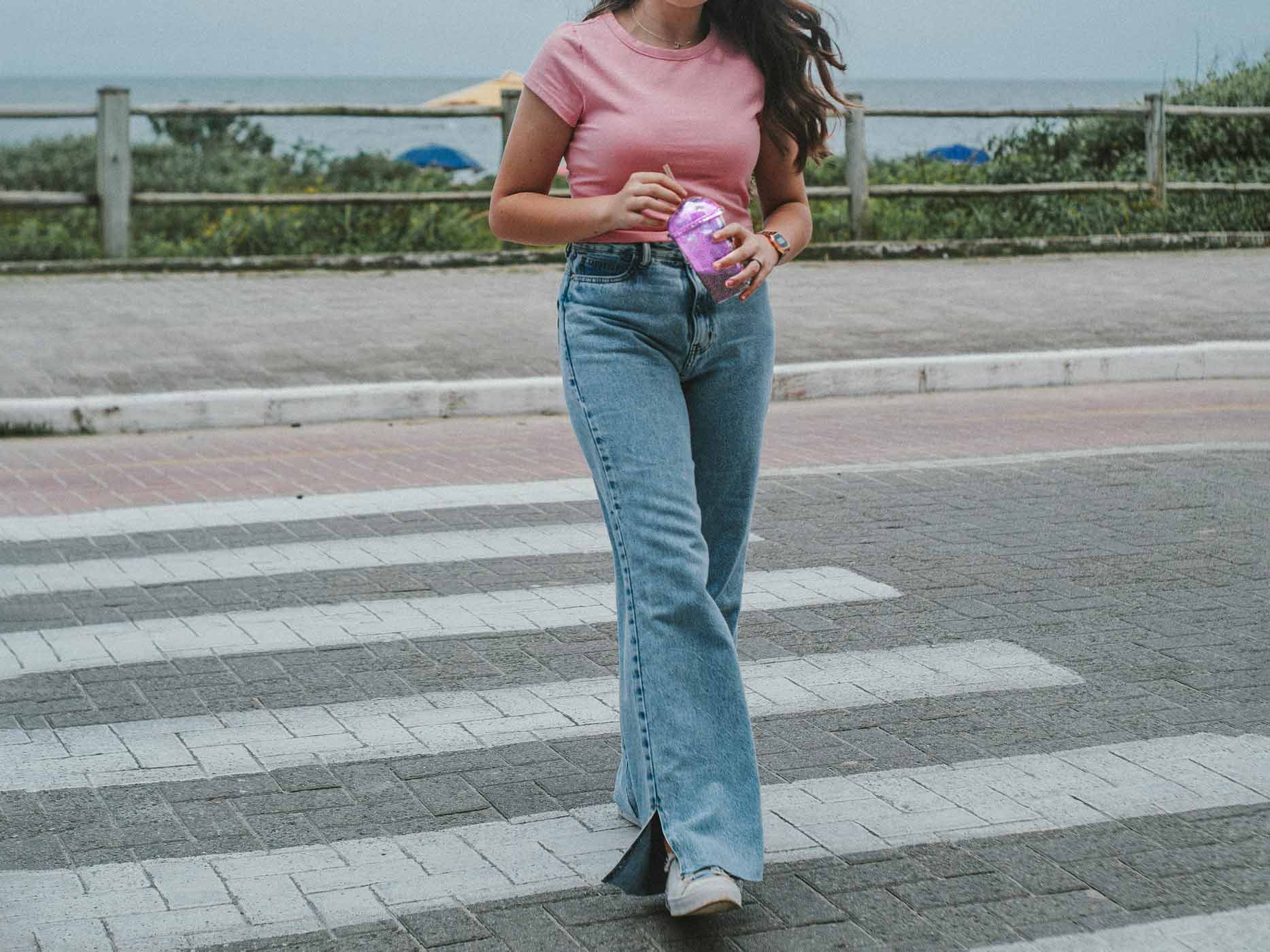 Frau geht über Straße und trägt eine hellblaue Highwaist Jeans