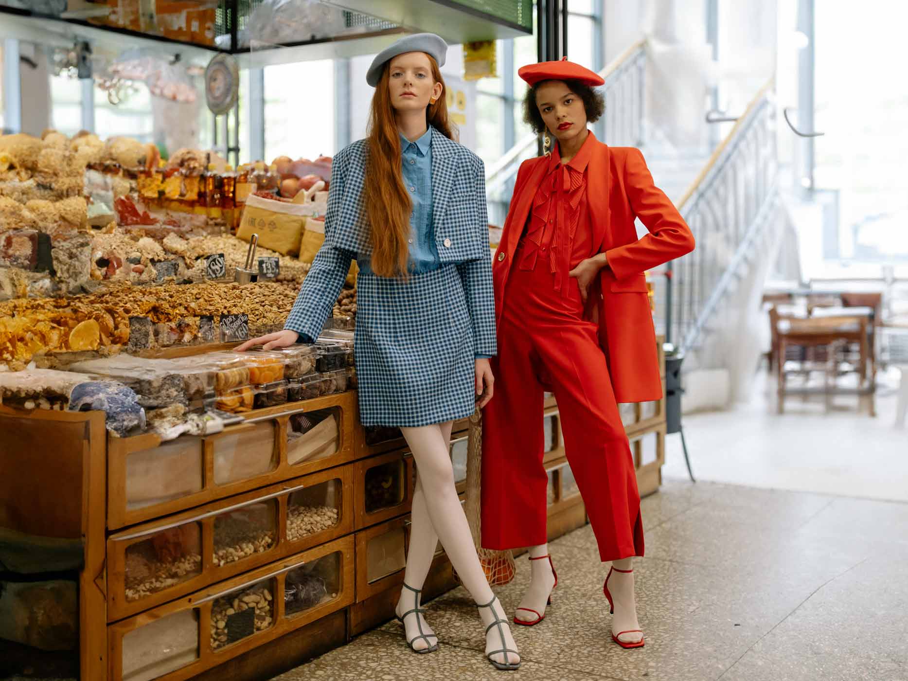 Zwei Frauen tragen monochrome Outfits, eine ganz in Rot und die andere in Blau