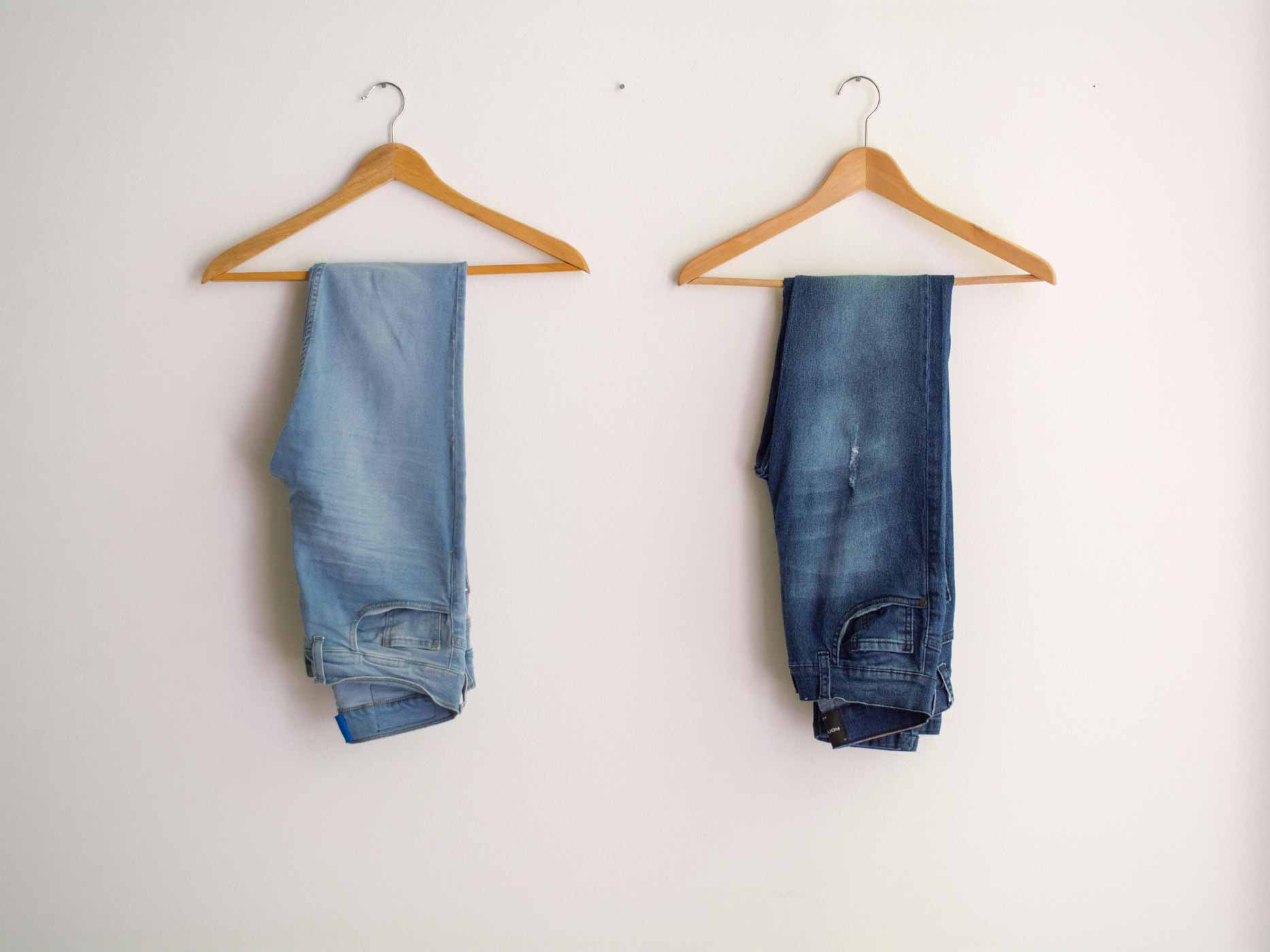 Zwei Jeans in unterschiedlichen Farben auf Kleiderbügeln